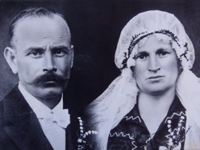 Schwarzweiß-Porträt eines Mannes mit Schnurrbart und einer Frau mit traditioneller Haube nebeneinander