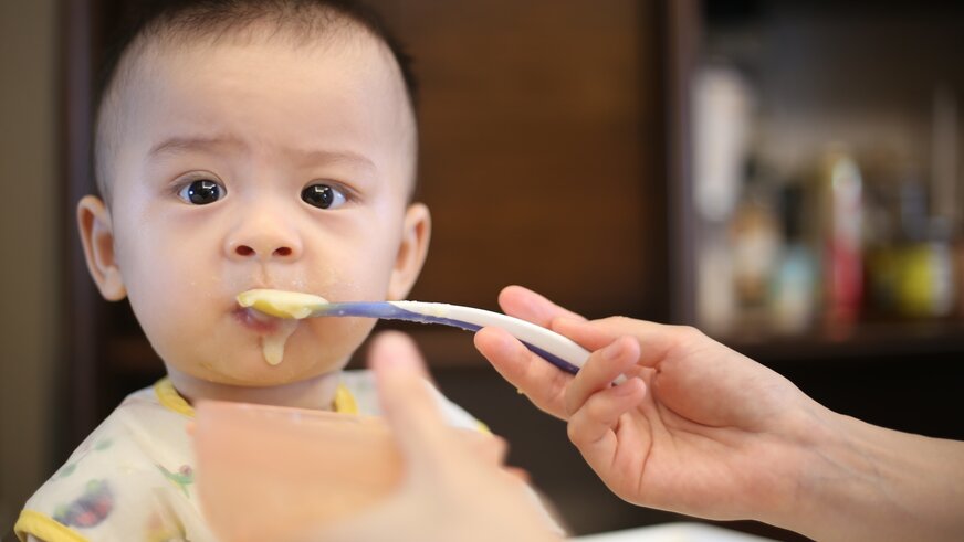 Baby wird mit Babybrei gefüttert