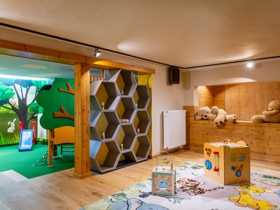 Kinderspielzimmer mit Holzregal, Spielwürfeln auf Teppich und Kuschelbären in Holznische