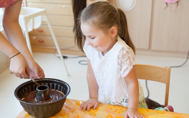 Mädchen sieht beim Backen im Kinder-Kochstudio zu
