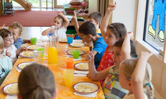 Kinder essen in der Kinderbetreuung zu Mittag