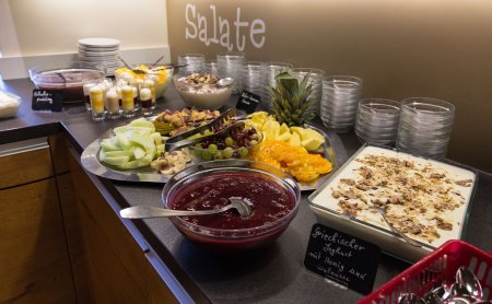 Buffet mit Obst, griechischem Joghurt mit Honig und Walnüssen und verschiedenen Desserts auf einer Theke