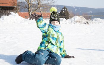 Junge spielt im Schnee