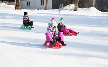 Kinder beim Rodeln am hauseigenen Rodelhang